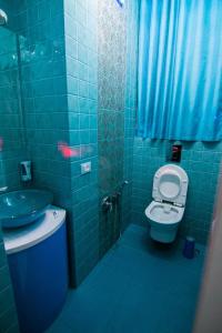 a blue tiled bathroom with a toilet and a sink at Odessa arkadiya 4 room and Jacuzzi Lux in Odesa