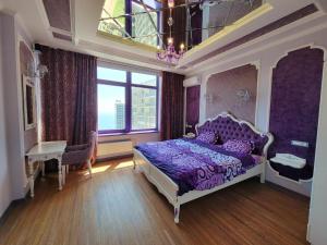 a bedroom with a purple bed and a table and a window at Odessa arkadiya 4 room and Jacuzzi Lux in Odesa