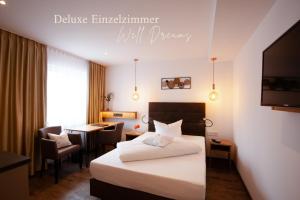a hotel room with a bed and a desk at Hotel Schwaiger in Glonn