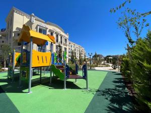 a playground with a slide in front of a building at Bellicity Apart Complex in Ravda