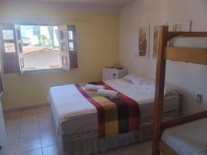 een slaapkamer met 2 stapelbedden en een raam bij Aconchego da Vovó Netinha in Maragogi