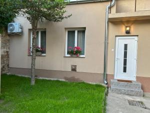 a house with two windows and a door with flowers at R59 Apartman with free parking in Pécs