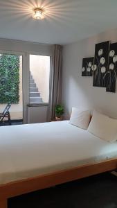 a bedroom with a large white bed with a window at Guesthouse Marie Therese in Brussels