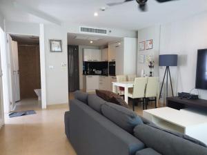 a living room with a blue couch and a table at Centara Avenue 2 Bedrooms Pool View in Pattaya Central