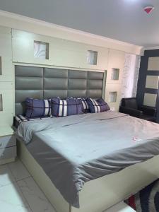 a bedroom with a large bed with purple pillows at Luxurious B in Lagos