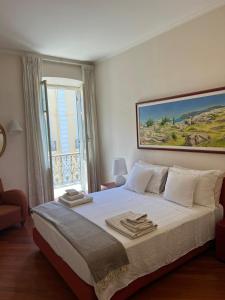 una camera da letto con un letto grande con asciugamani sopra di Casa in Centro a Sanremo