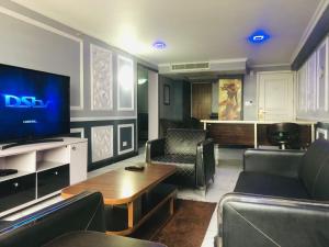 a living room with a tv and a table and chairs at Luxurious B in Lagos