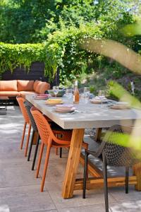 een tafel met stoelen en wijnglazen op een patio bij Vuurtorenveld 136 - Het Oude Nieuwland Ouddorp - NOT FOR COMPANIES in Ouddorp