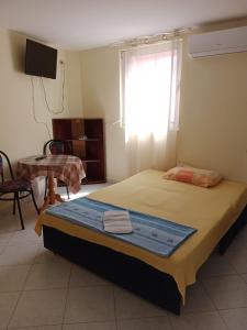 a bedroom with a bed with a window and a table at Vila Sisevic in Budva