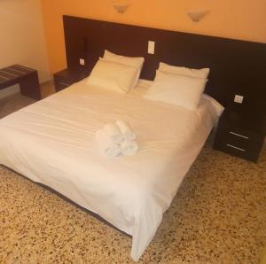 a large white bed with two white towels on it at Hermes in Agia Marina Aegina