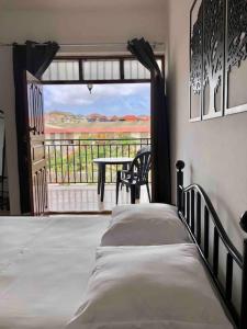 Schlafzimmer mit einem Bett und Blick auf einen Balkon in der Unterkunft Tarrafal Ecodécor Full House in Tarrafal