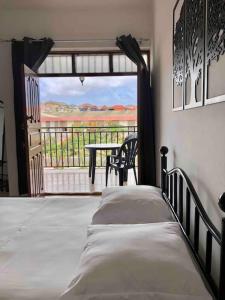 a bedroom with a bed and a view of a balcony at Tarrafal Ecodécor Full House in Tarrafal