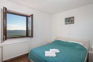 1 dormitorio con 1 cama con 2 toallas en Rural Accommodation Veselic, en Pridvorje