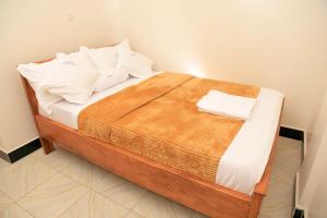 uma cama com duas almofadas num quarto em Scindia Suites hotel em Jinja