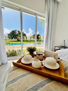 bandeja con platos y tazas en una mesa de un dormitorio en Relax Apto Pool and Golf View in Hard Rock Golf en Punta Cana