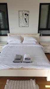 ein weißes Bett mit zwei Handtüchern darüber in der Unterkunft נס הבריאה in Midreshet Ben Gurion