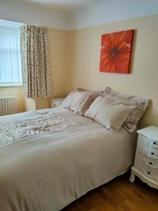 a bedroom with a large white bed and a window at Linksway House in Birkenhead
