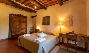 una camera con un letto e una scrivania con asciugamani di Podere Argena a Lucignano