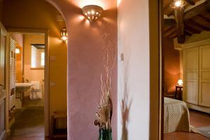 un pasillo con un jarrón con flores en una habitación en Podere Argena, en Lucignano 64 fotos más