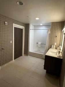 a bathroom with a tub and a sink and a shower at Home2 Suites By Hilton Hinesville in Hinesville