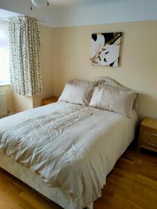 a white bed in a bedroom with a window at Linksway House in Birkenhead