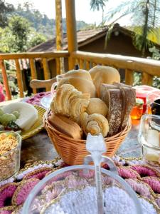 a table with a basket of bread and other foods at Chalés Paraty Real in Paraty