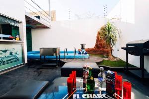 a living room with a table with drinks and a pool at El Charco Culiacán in Culiacán