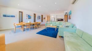 a living room with a blue couch and a table at 4-4 The Esplanade, Cowes - Cscape in Cowes