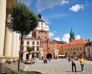 a group of people walking around a city with a clock tower at #OLEJNA stare miasto... MKVADRAT in Lublin