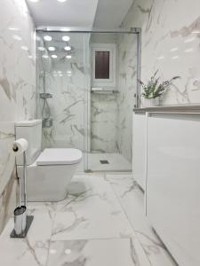 a white bathroom with a toilet and a shower at Apartamento Edificio Astoria in Benidorm