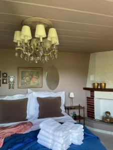 um quarto com uma cama com lençóis brancos e um lustre em Sete Fontes - Agarone Holiday Nest em Agarone