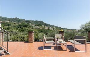 eine Terrasse mit 2 Stühlen und einem Tisch mit einem Berg in der Unterkunft 5 Bedroom Gorgeous Home In Podenzana in Podenzana