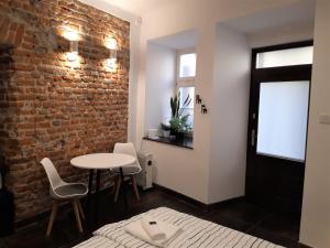 a room with a brick wall and a table and chairs at #OLEJNA stare miasto... MKVADRAT in Lublin