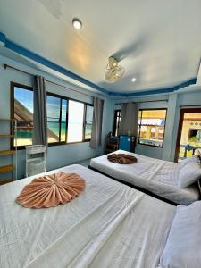 a large bedroom with two beds and windows at Euphoria Bungalow in Haad Yao