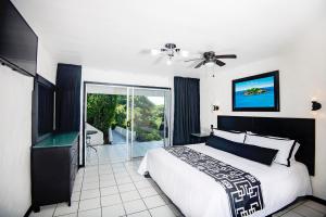 a bedroom with a bed and a sliding glass door at Villa Roca Boutique Resort & Suites - ADULT ONLY in Puntarenas