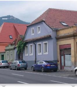 a row of houses on a street with parked cars at Blue House in Braşov