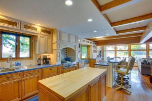 a large kitchen with wooden cabinets and a large island at Lakefront Cadillac Retreat with Sauna and Boating! in Cadillac