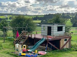 a tiny house with a slide and play equipment at Stardust Getaway Tiny-Home E32AK40 in Piltown