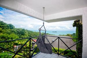 a balcony with a hammock and a view of the ocean at Villa Roca Boutique Resort & Suites - ADULT ONLY in Puntarenas
