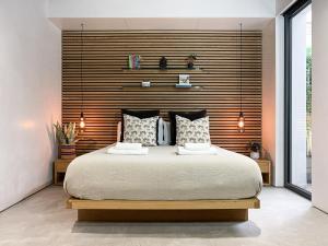 una camera con un grande letto con testiera in legno di Luxury Urban Oasis with Garden and Private Studio a Londra