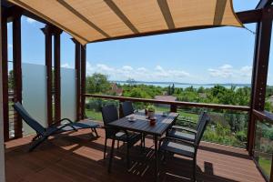 einen Tisch und Stühle auf einer Terrasse mit Aussicht in der Unterkunft Aranymandula apartmanok in Balatonakali