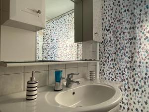 W łazience znajduje się umywalka i lustro. w obiekcie COZY & QUIET CITY APARTMENT w mieście Tríkala