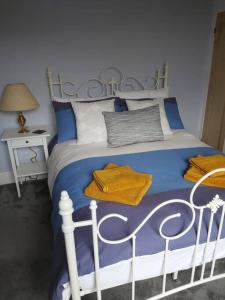 a blue bedroom with a bed with a white and blue comforter at Charming 2 double bed cottage style house in Bristol