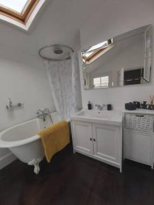 a bathroom with a tub and a sink and a mirror at Charming 2 double bed cottage style house in Bristol