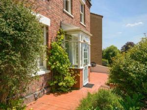 a brick house with ivy growing on the side of it at Charming 2 double bed cottage style house in Bristol