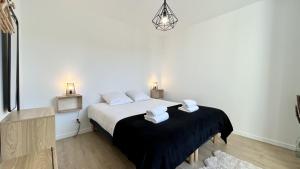 a bedroom with a bed with two towels on it at L'Escale in Fort-Mahon-Plage