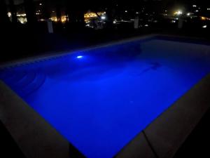 ein Schwimmbad in der Nacht mit blauer Beleuchtung in der Unterkunft Casa Rural Lomillas de Canca in Alora