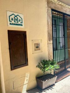 un edificio con una puerta y una planta delante en ANJ ESTUDIO TEMPLETE, en Guadalupe