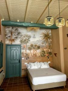 1 dormitorio con 1 cama y una pintura de palmeras en ANJ ESTUDIO TEMPLETE, en Guadalupe