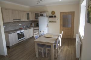 a kitchen with a wooden table and a white refrigerator at Domek u Dyje in Znojmo